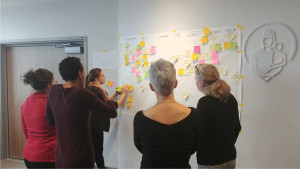 un groupe de perosnnes regarde et discuter autour d'une cartographie représentant le parcours des patients