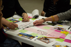 Des mains de personnes qui sont entrain de dessiner par dessus un plan d'aménagement de la Maison de la culture afin d'imaginer des solutions ensemble.